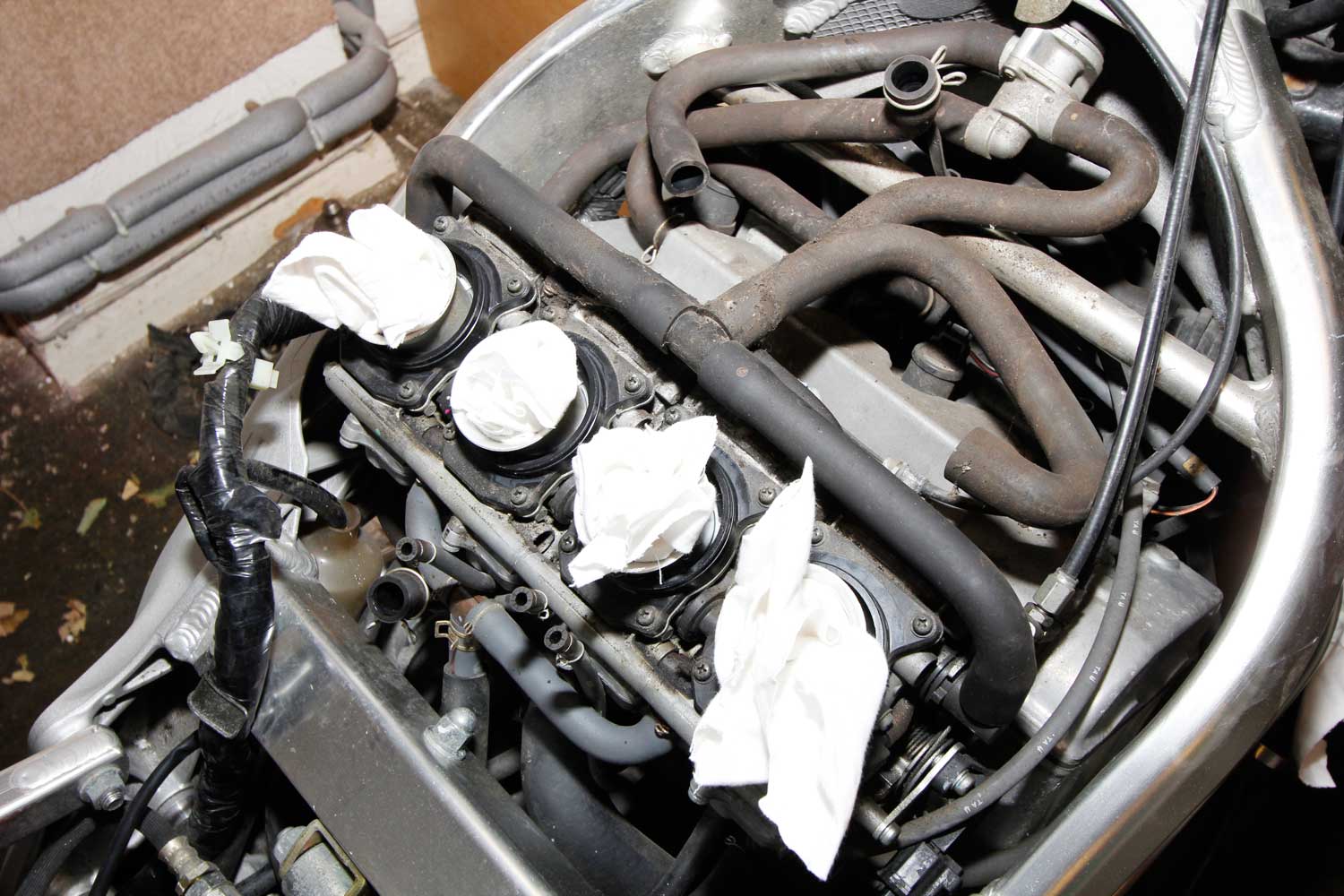 5: With the air box removed, gently plug the carb inlets with clean rags. Also take some time to study the layout of the pipework, and take a photo with your phone too.