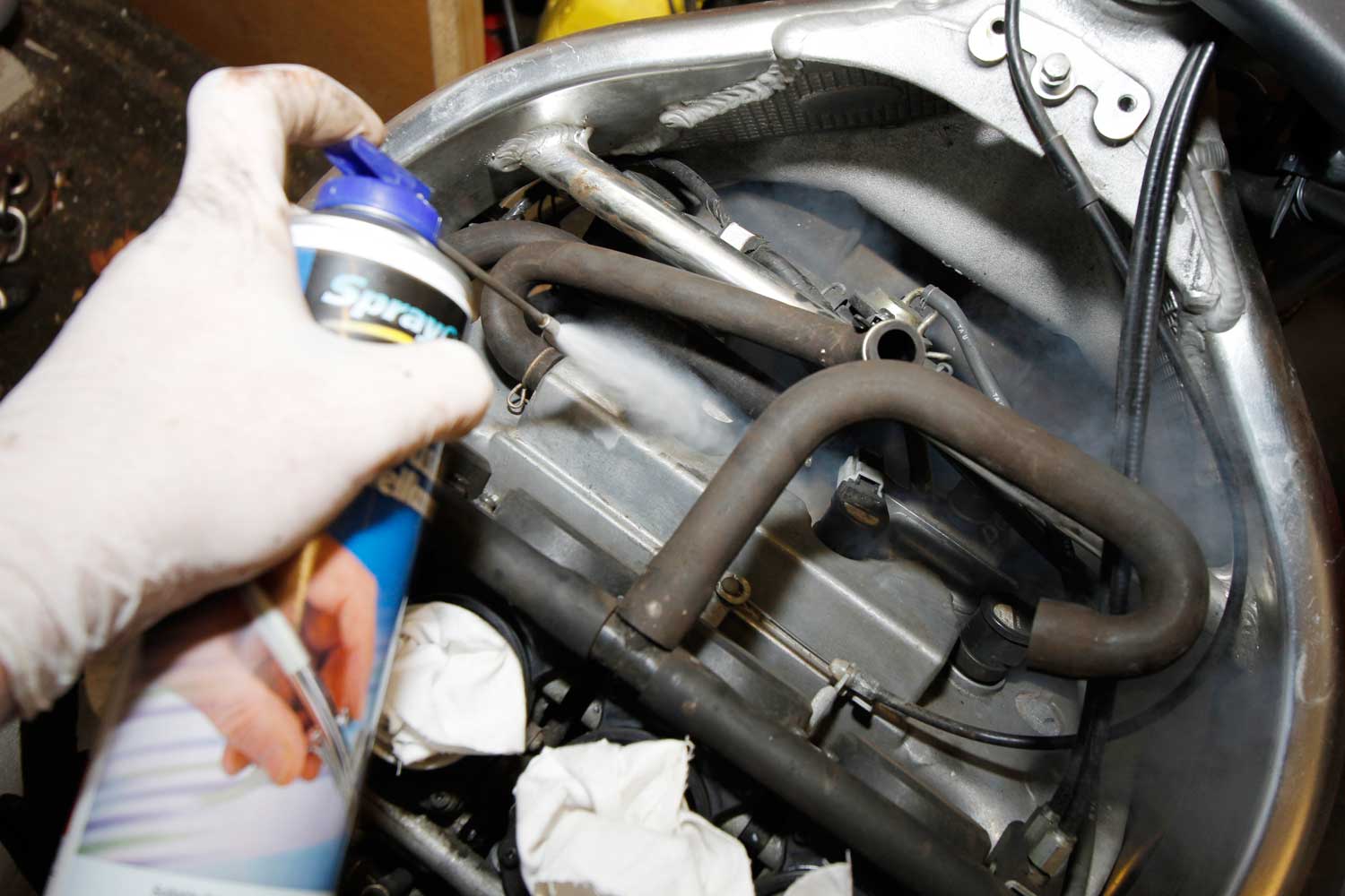 6: I’ve stripped out some of the emission-control pipes, to make access to the plugs easier. I don’t have an airline, so I bought a can of airbrush propellant from Halfords, and attached a Kenro Air Duster Valve (£8.99 from eBay) to let me blow any grit and dust away that could fall into the cylinder when the plugs come out.