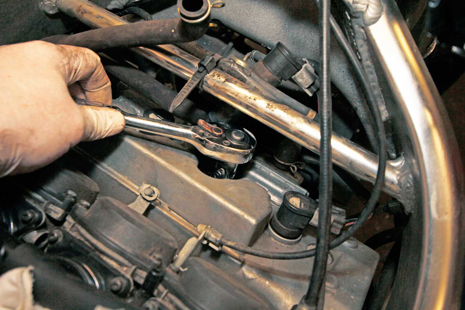 7: Pull the coils out of the cylinder head. They’re only just the right length to go back in the right holes, so you shouldn’t be able to muddle them up. Then use a ratchet with a spark plug socket (it’s got a rubber grommet inside to hold onto the plug once it’s free) to remove the plug.