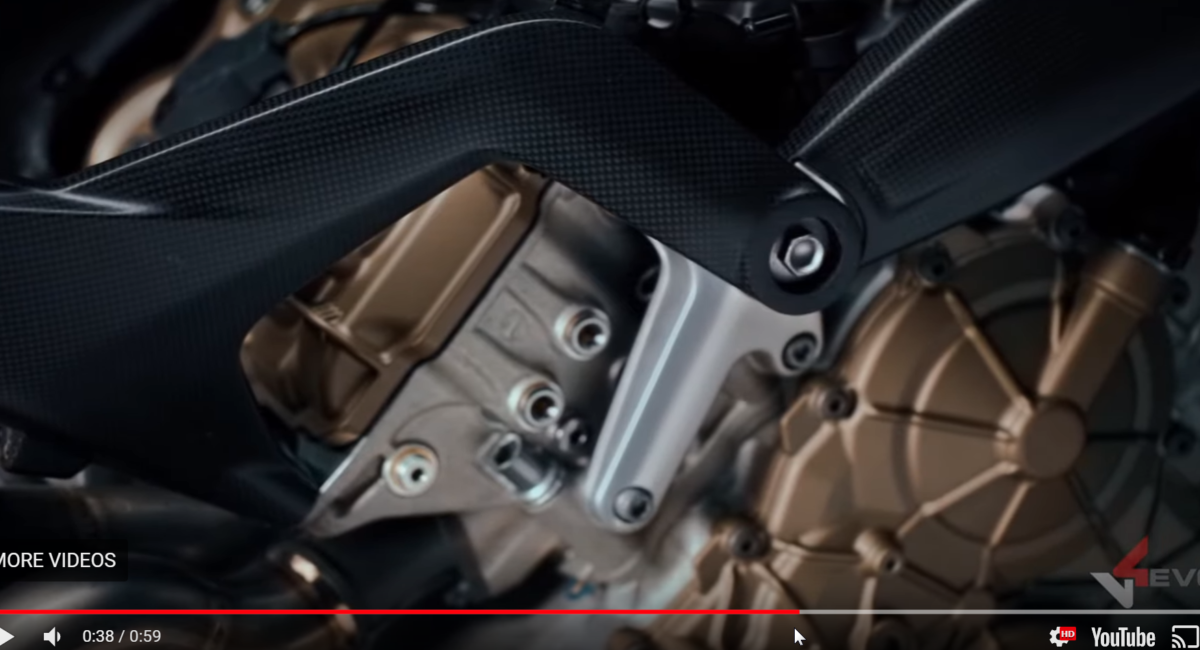 The carbon subframe bolts directly to the top mount, overlapping the carbon frame spur.