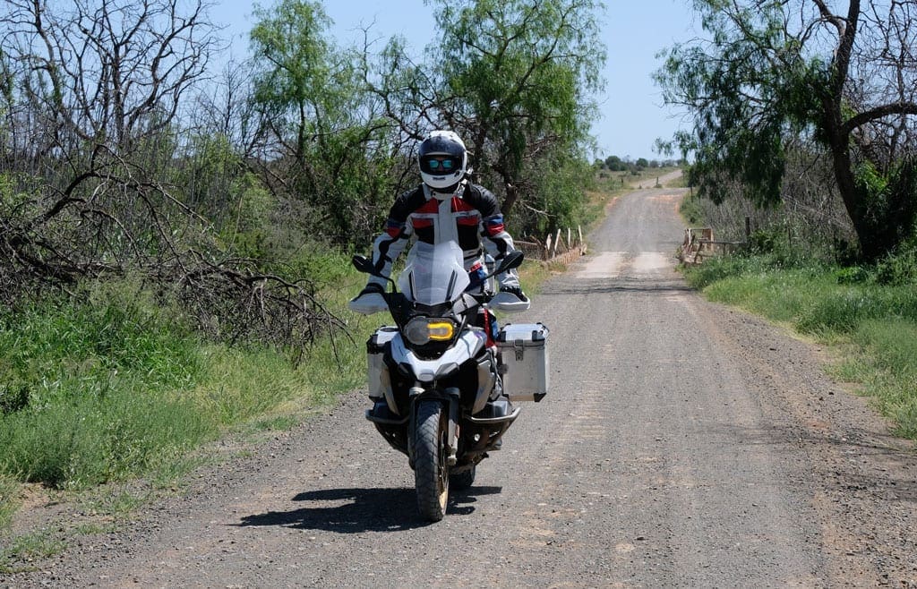 Turning back 3 One of the bikers rides along a dirt road on their bike.