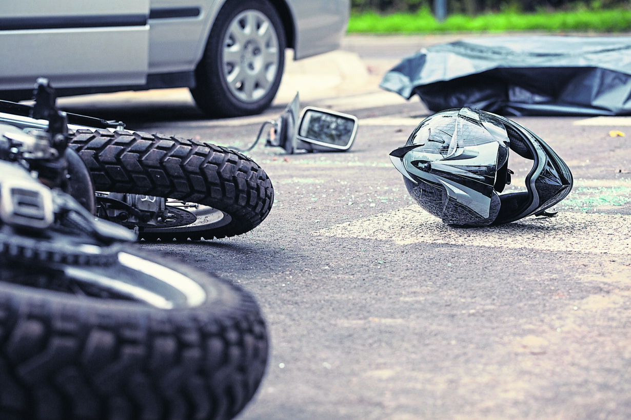 Motorcycle and helmet on the street after dangerous traffic incident